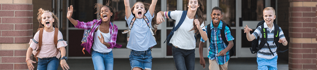 School kids running as they leave the school building