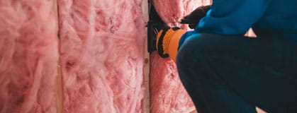 Person installing insulation in a house