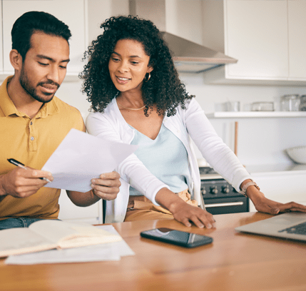 Couple reviewing their energy choice with laptop and phone in the kitchen.