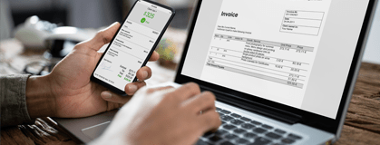 Businessman's hands working on Invoice on laptop.