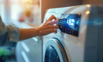 Close up of a person pressing a button on a washing machine. 