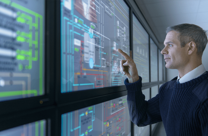 Man examining screen in engine room. 