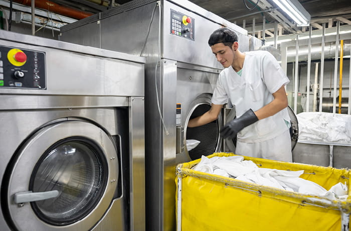 Man loading industrial washing machine