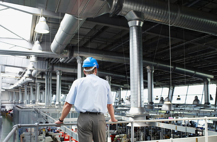 Man in hard hat looking at factory floor