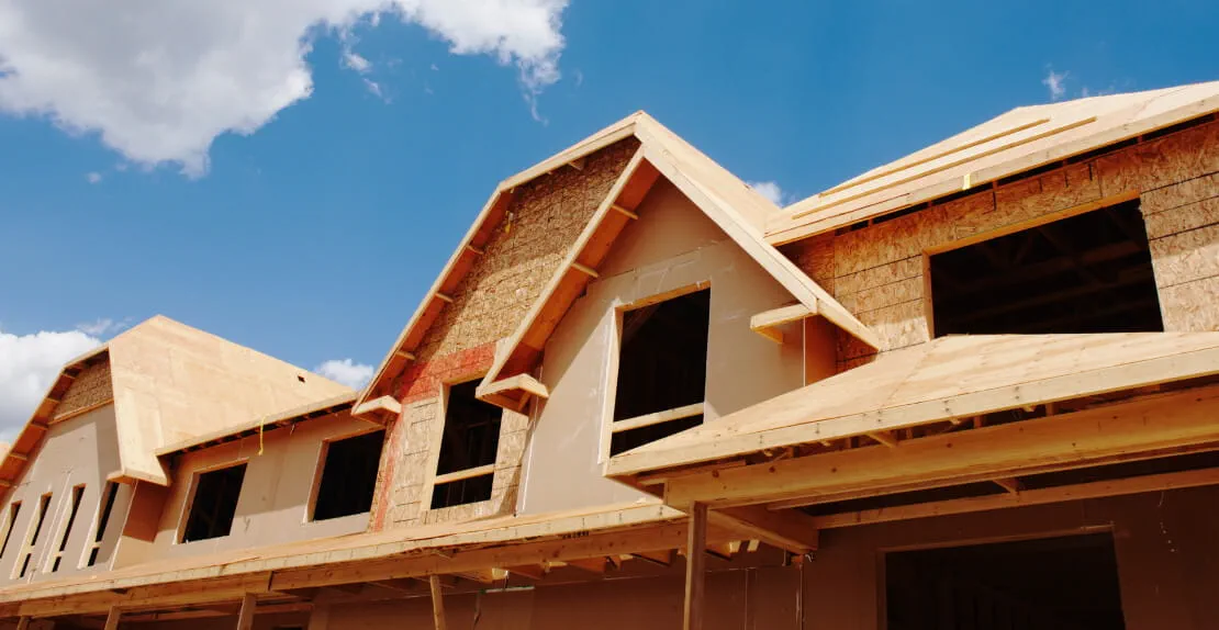 Image of a house construction frame on a clear summer day.