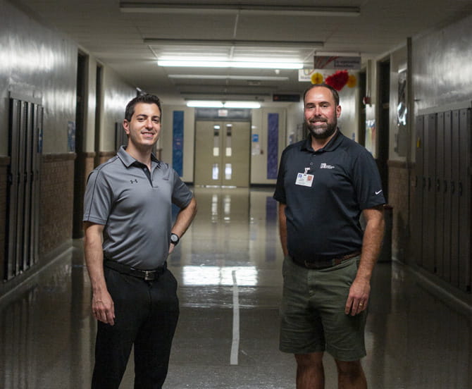 Two men standing in the hallway.