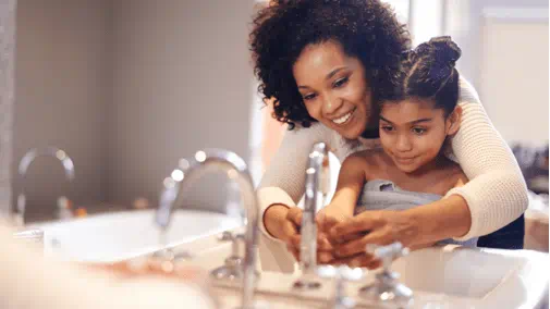 Mom washing child's hands heated water