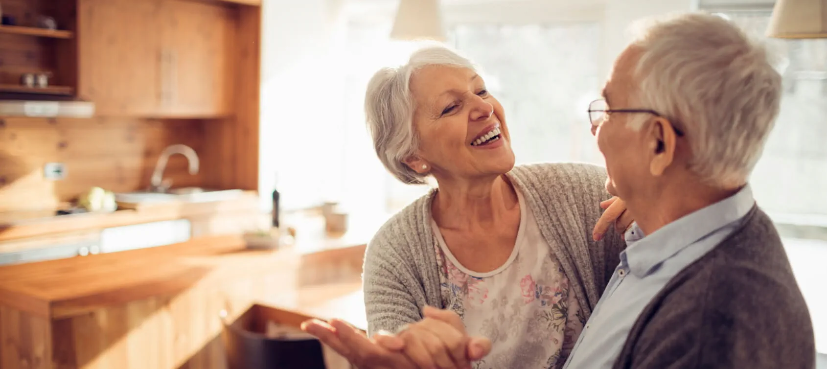 Man and woman dancing slowly in their living room.