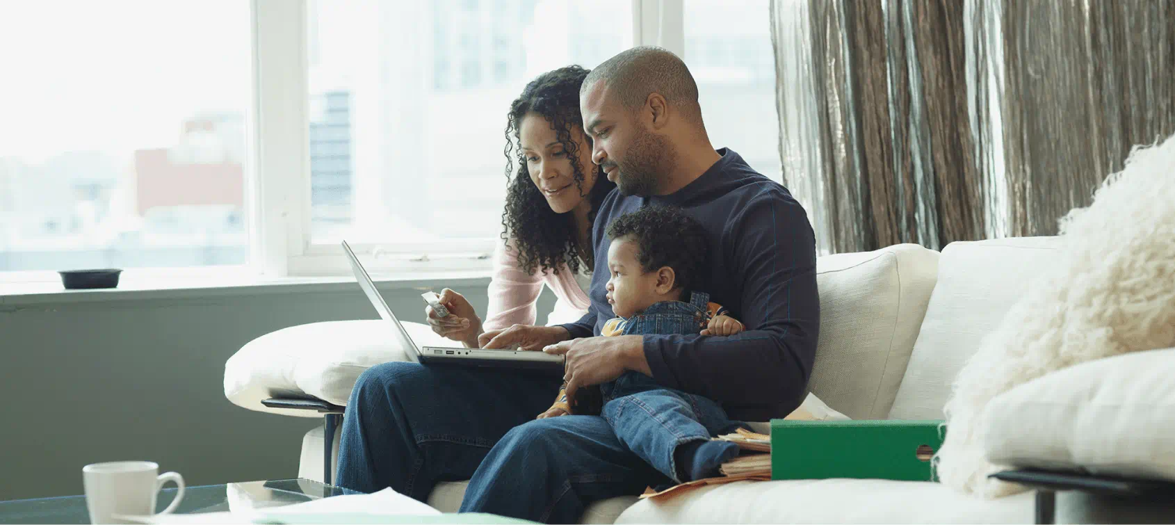 Family of three using a laptop together