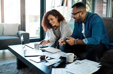 Two people planning financial matters with a pc and paperwork