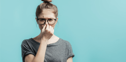 Woman holding her nose